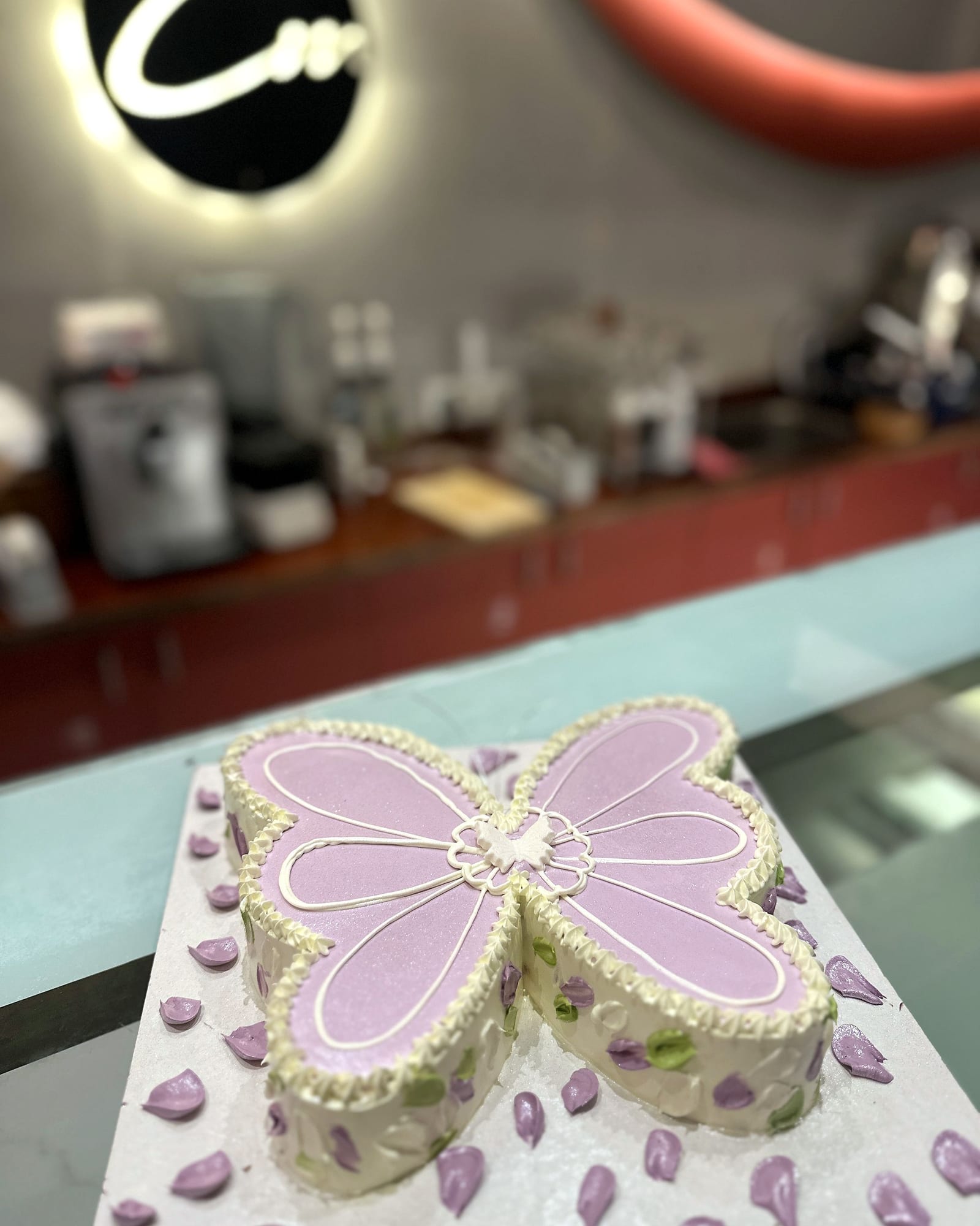 Butterfly-shaped celebration cake in lilac and cream