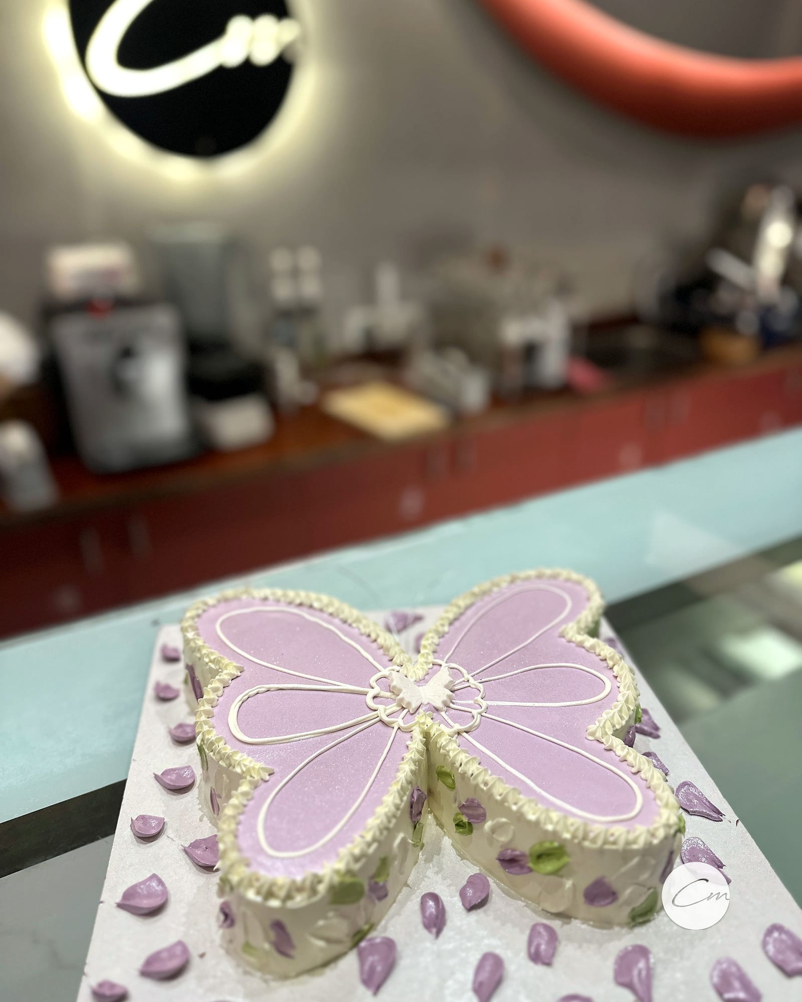 Butterfly-shaped celebration cake in lilac and cream