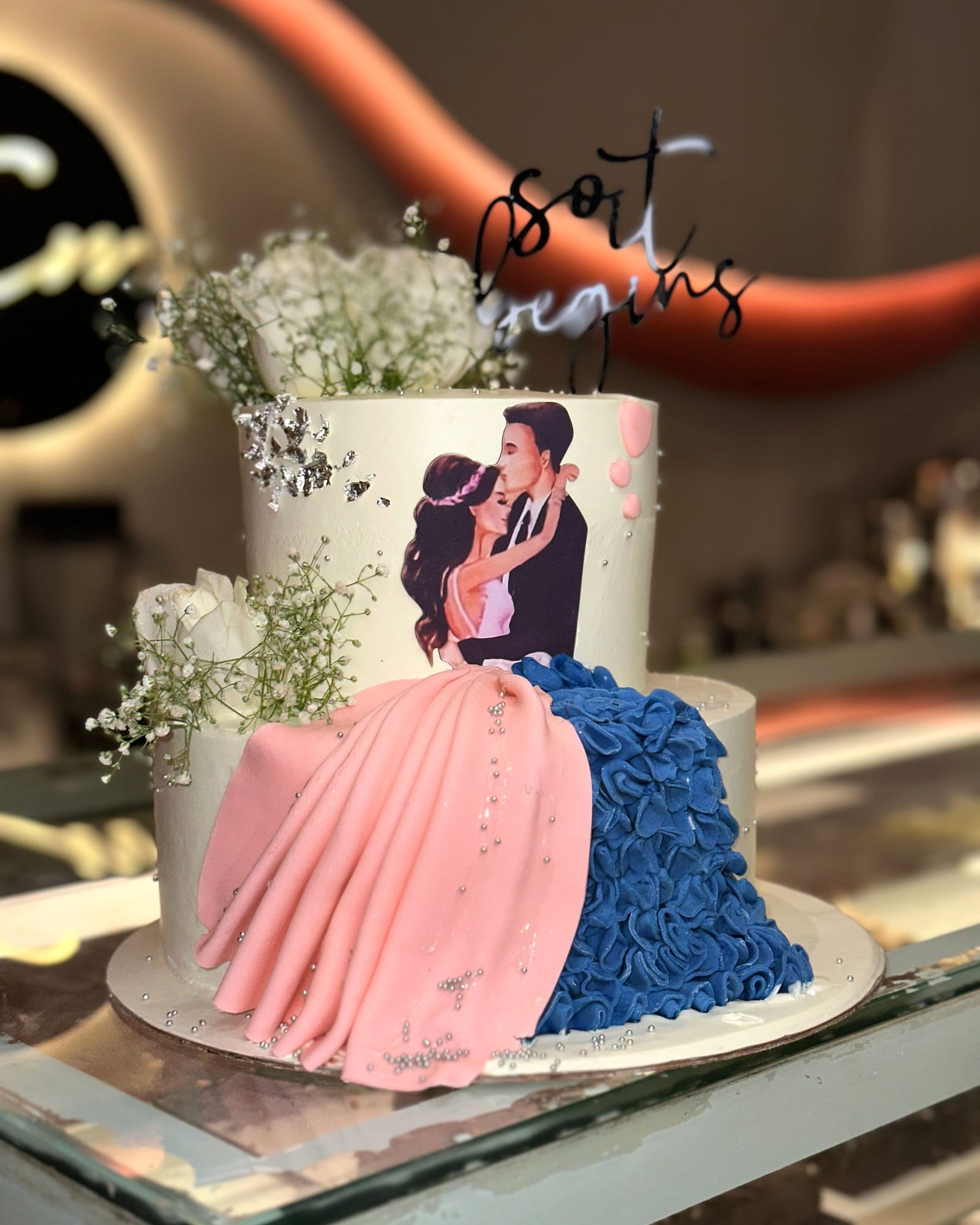 Engagement cake with a hand-piped couple and a ruffled gown