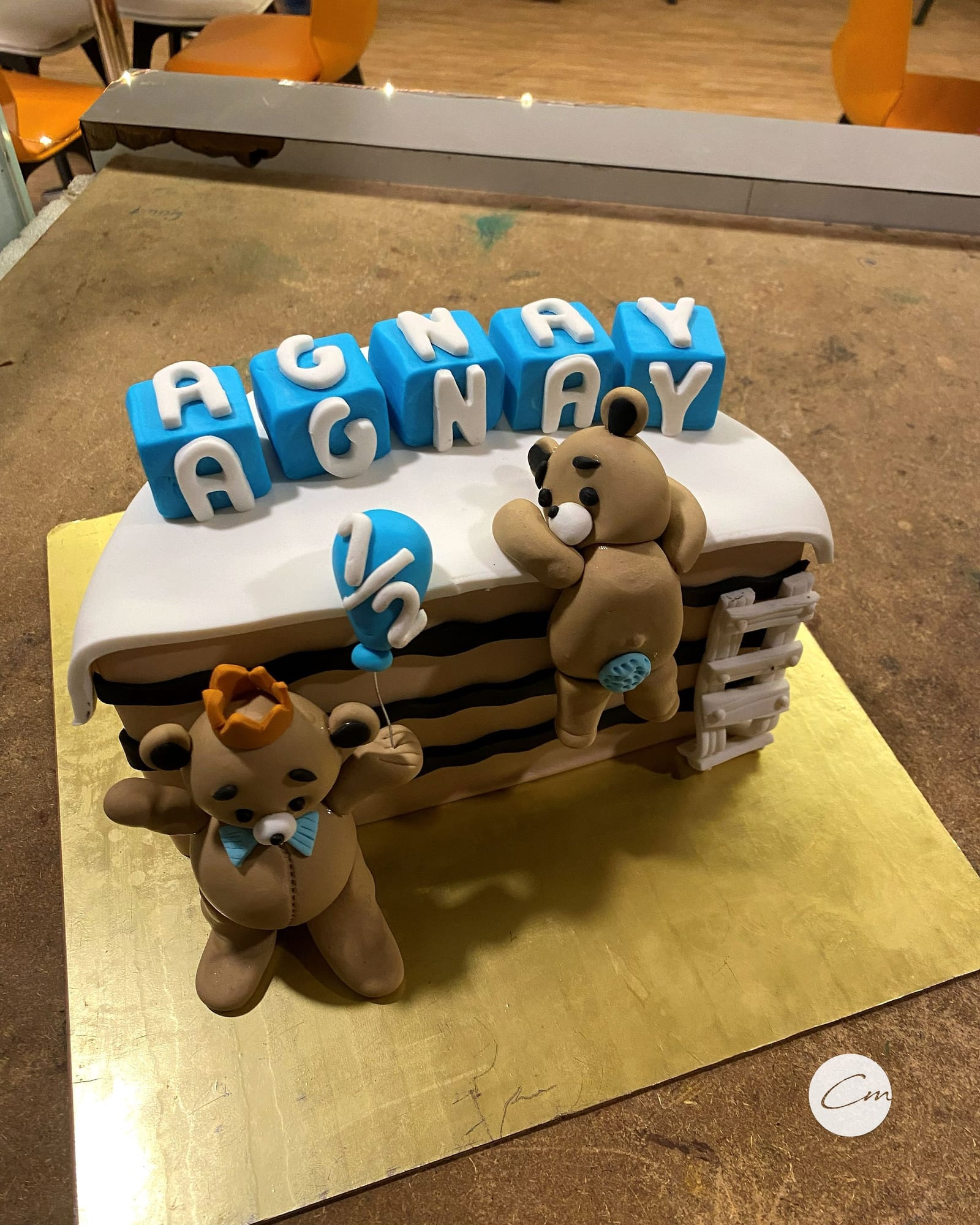 Half-birthday cake with fondant name blocks and a bear topper