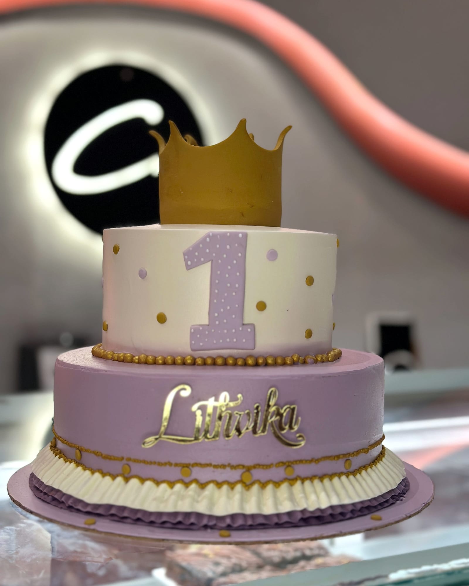 First-birthday cake in lilac and gold with a fondant crown
