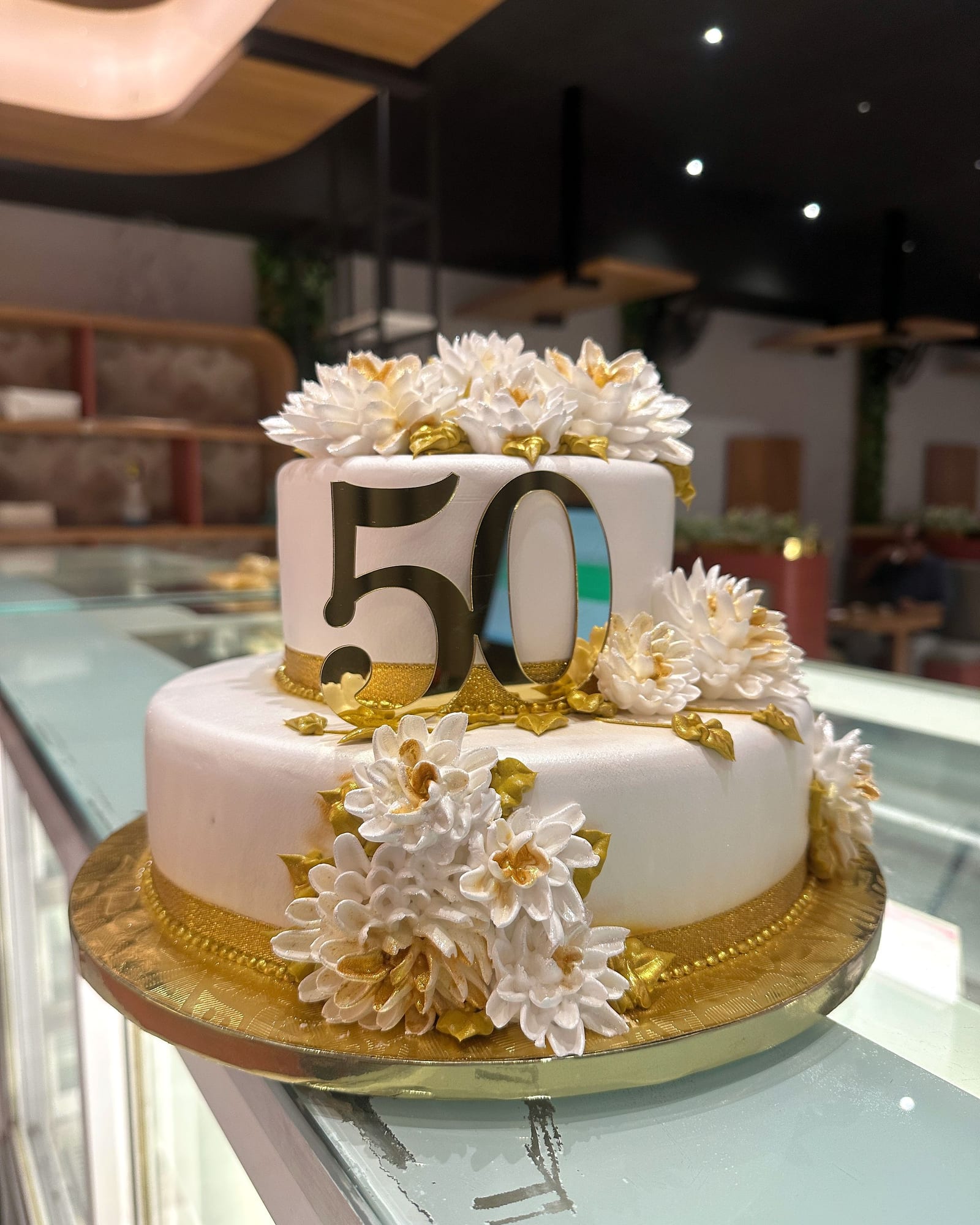 Two-tier fiftieth birthday cake with sugar flowers