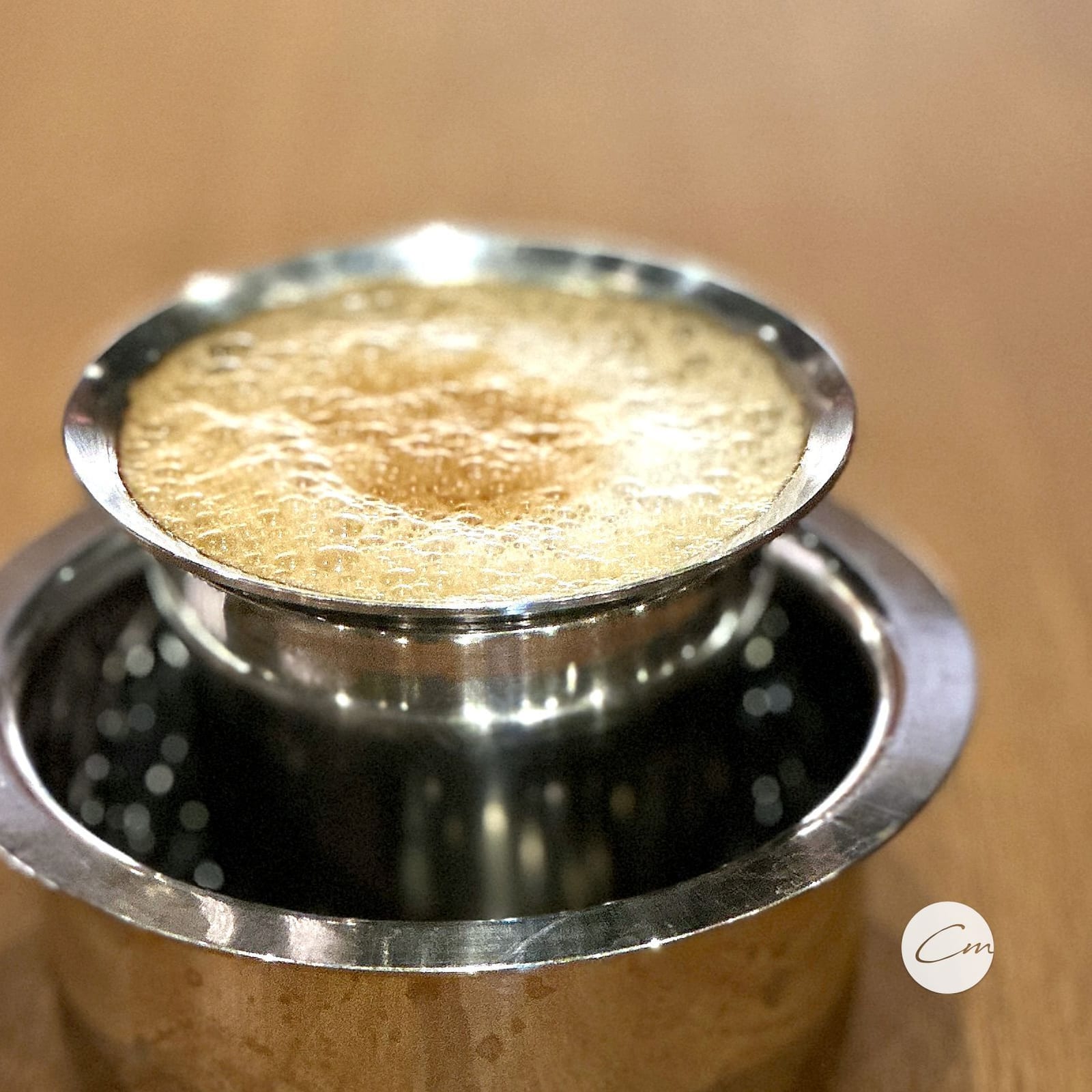 South Indian filter coffee, the crema swirled by hand between tumbler and dabara
