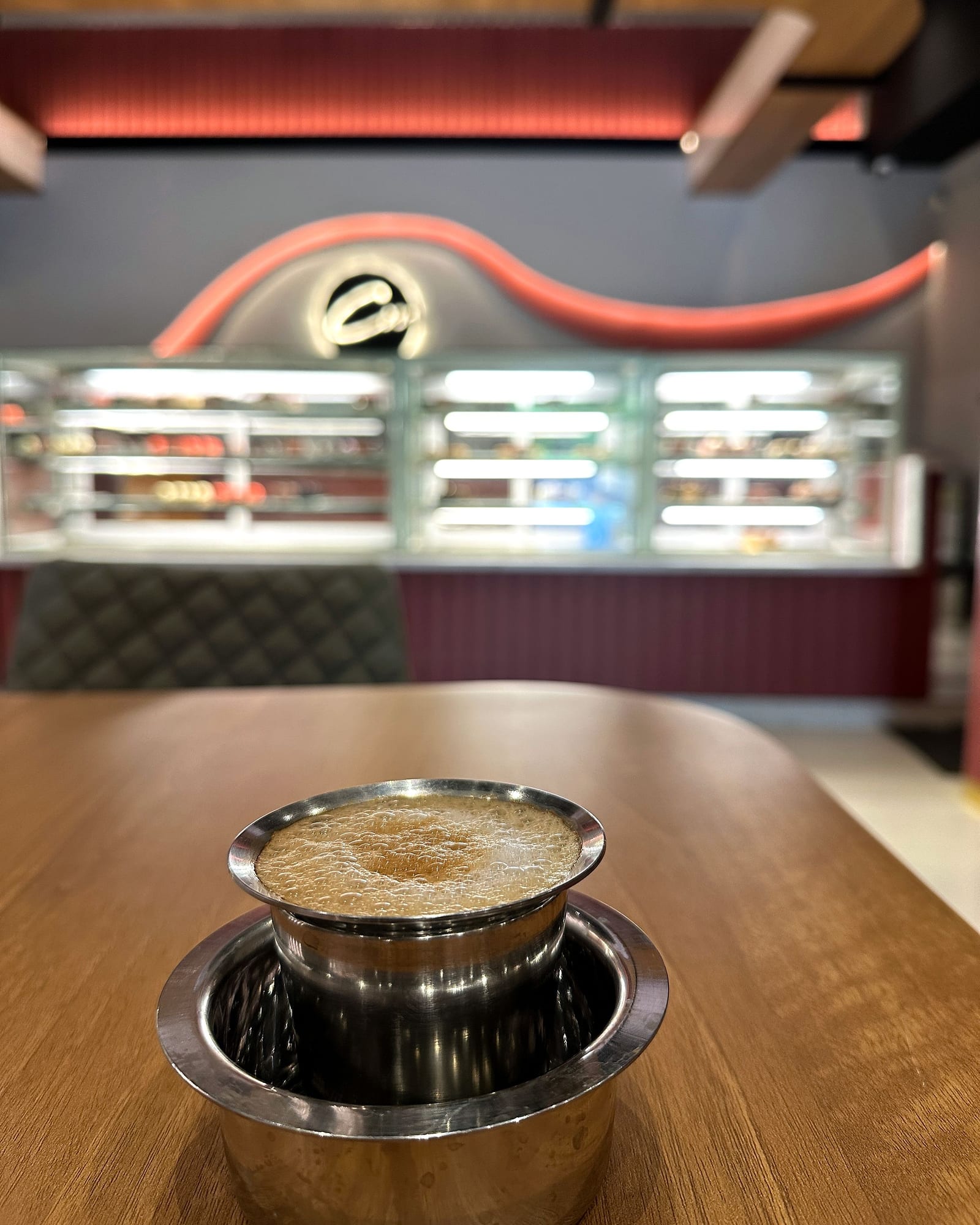 Filter coffee on the table with the dessert counter behind