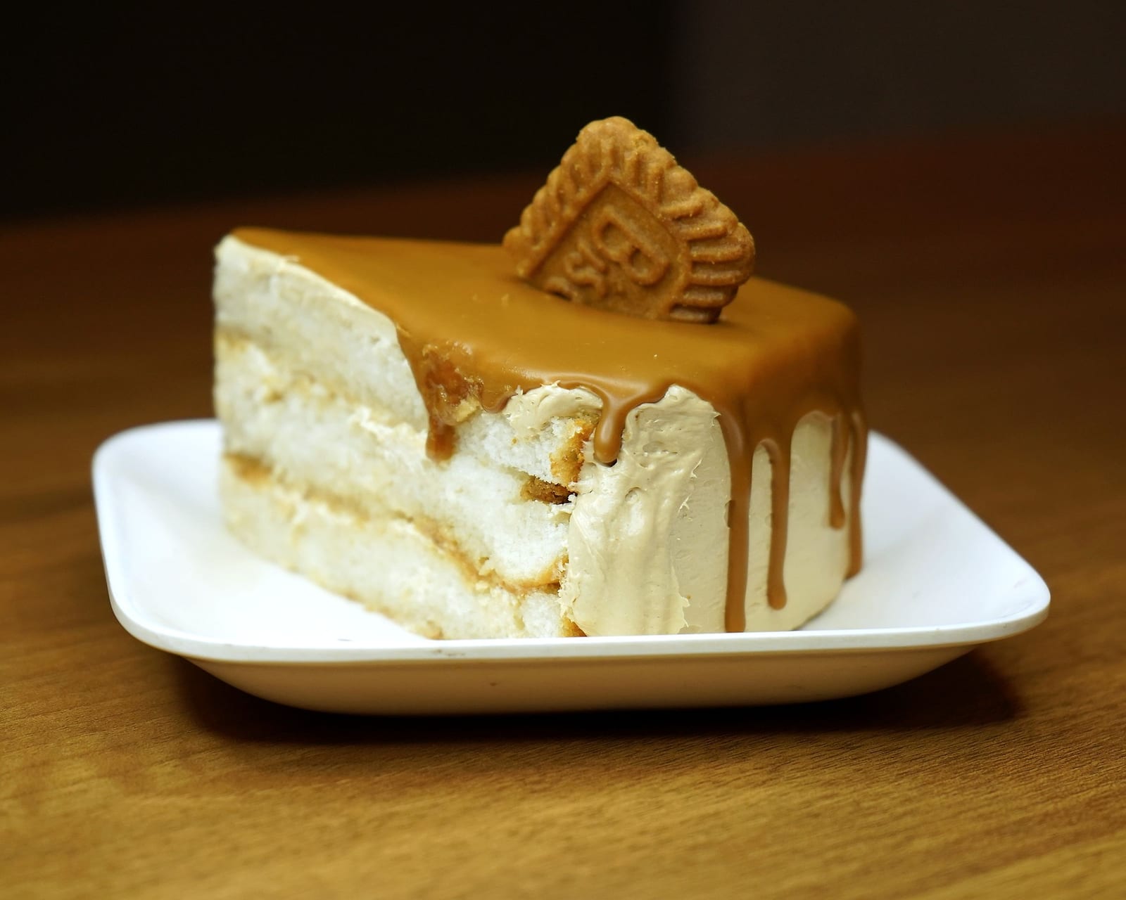 A Biscoff slice with caramel drip and a Lotus biscuit