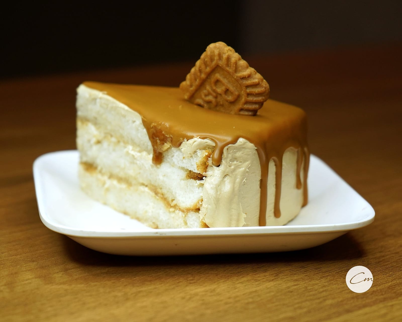 A Biscoff slice with caramel drip and a Lotus biscuit