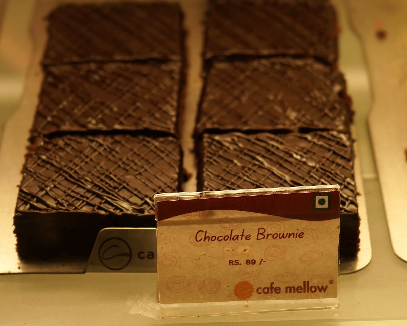 A tray of freshly cut chocolate brownies in the display case