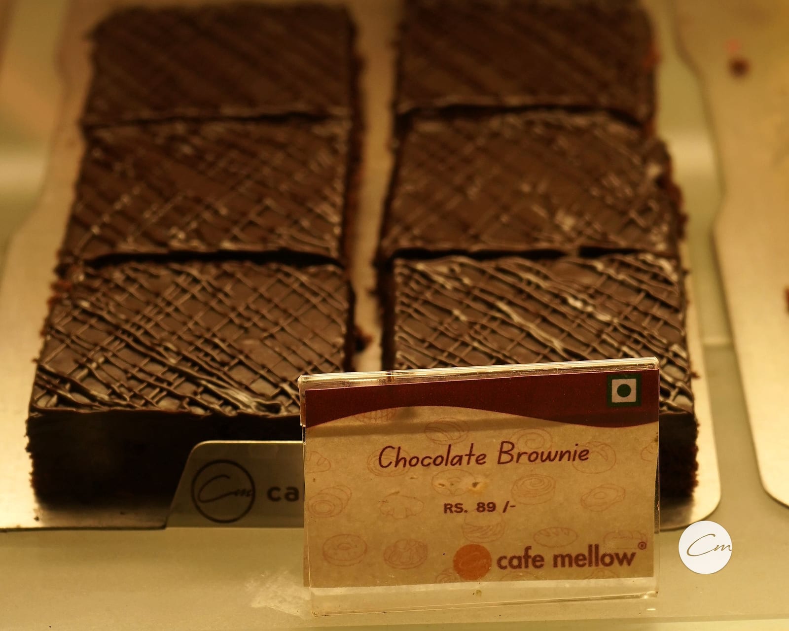 A tray of freshly cut chocolate brownies in the display case