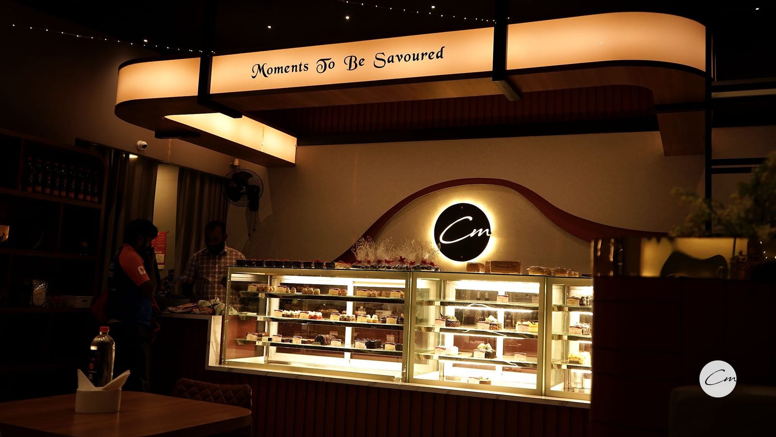 The Café Mellow counter in Tiruppur, dessert cases lit under the “Moments To Be Savoured” sign